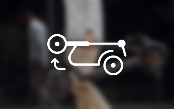 Значок самоката, складеного для транспортування, зі стрілкою, позначеною колесом, на тлі розмитого зображення людини