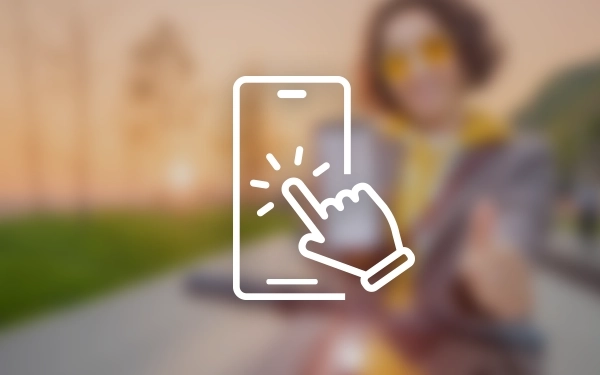 Значок смартфона з рукою, що торкається екрана, на розмитому фоні людини в жовтих окулярах та светрі.