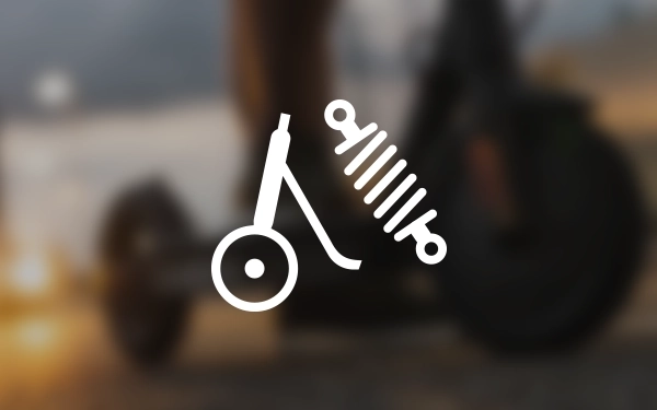 Значок скутера із символом амортизатора, що представляє систему підвіски, на розмитому фоновому зображенні поїздки в сутінках