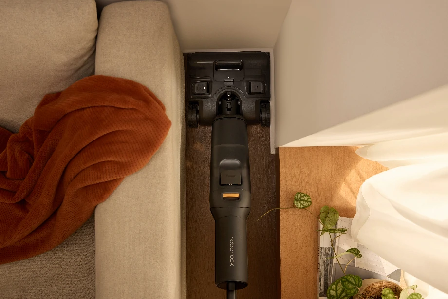 Пилосос вставили в щілину між диваном і стіною.