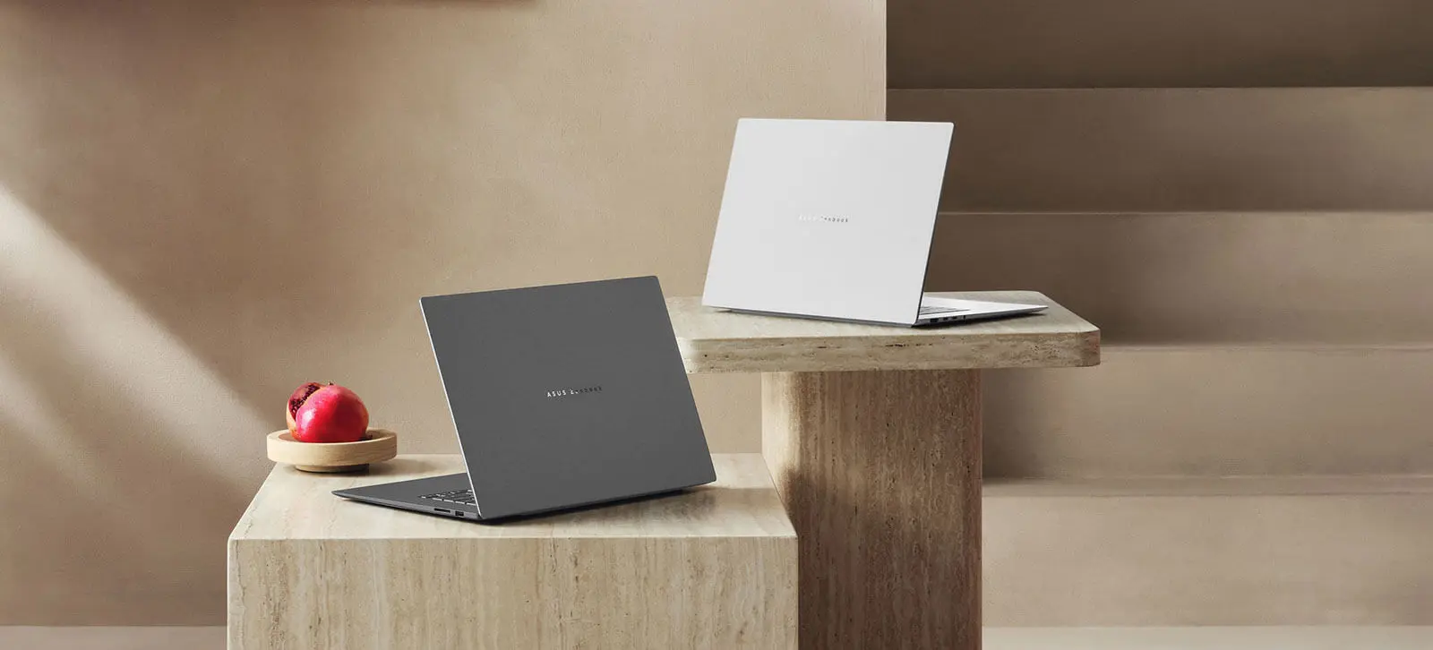 Zenbook S16 в обох доступних кольорах стоїть на бетонних постаментах