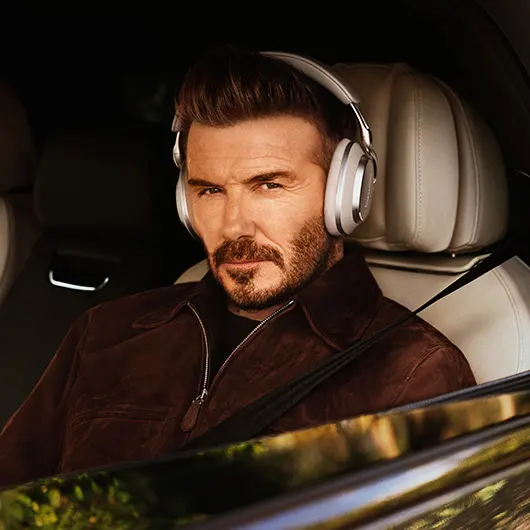 Девід Бекхем сидить у своїй машині з відкритим вікном і в навушниках Warm Stone Px8 S2.