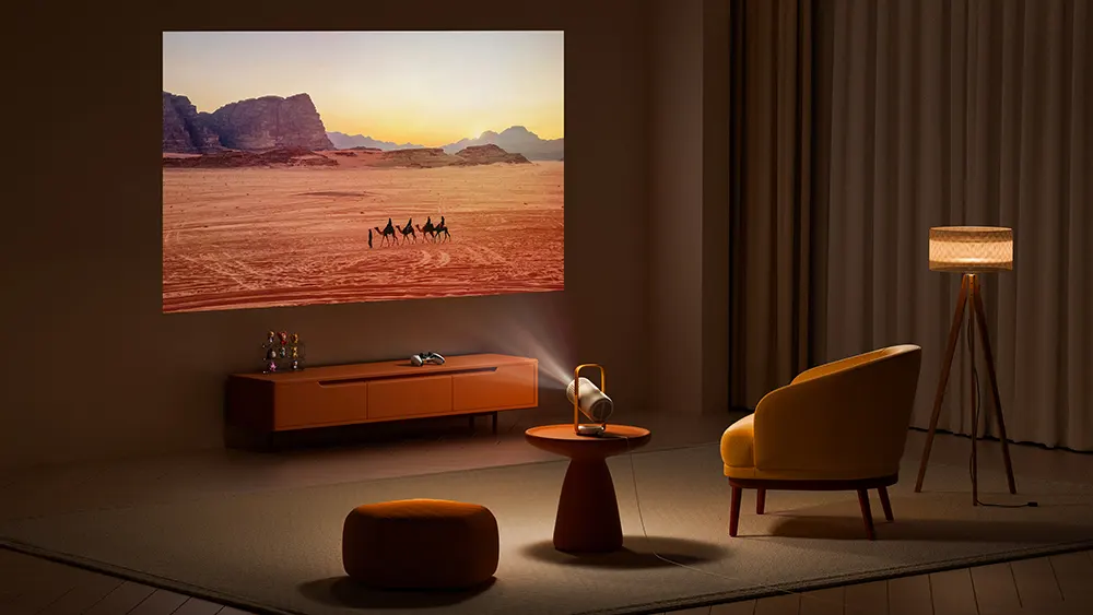 Затемнена вітальня з Vibe One на столі посередині та яскравим, чітким зображенням, що проектується на стіну.