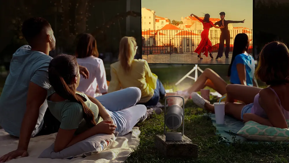 Вечір, компанія друзів відпочиває на свіжому повітрі, а XGMI VIbe One робить їхній час приємнішим, на якому зображено танцюючу пару.