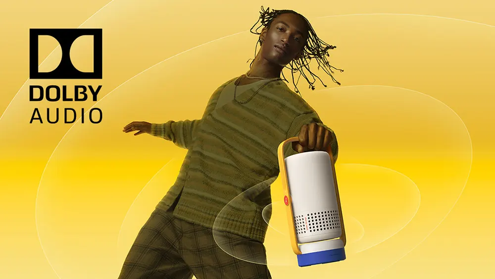 Чоловік тримає XGIMI Vibe One в руці, як ліхтар, яскраво-жовтий фон підкреслює динаміку