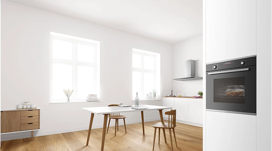 Вбудована духовка розташована перед кухнею відкритого планування. Великий обідній стіл зі стільцями знаходиться в центрі кухні.