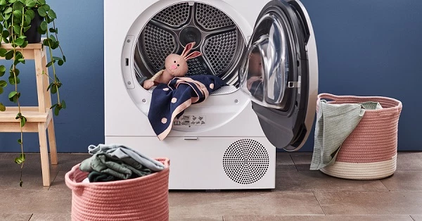 Сушарка Bosch з відкритими дверцятами, м’якою іграшкою та одягом у барабані.