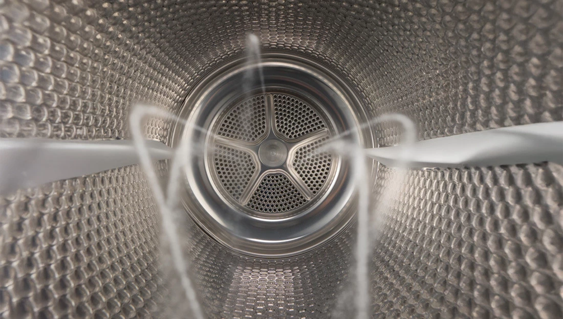 Внутрішня частина барабана сушильної машини Bosch з видимими перфораціями та паровими форсунками.