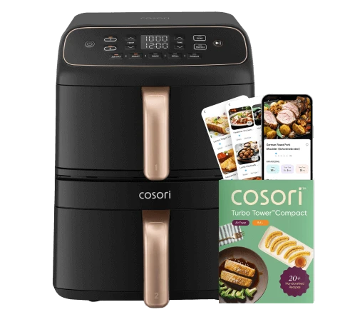 Фритюрниця Cosori стоїть поруч зі смартфоном з рецептами та паперовою кулінарною книгою з ідеями страв.