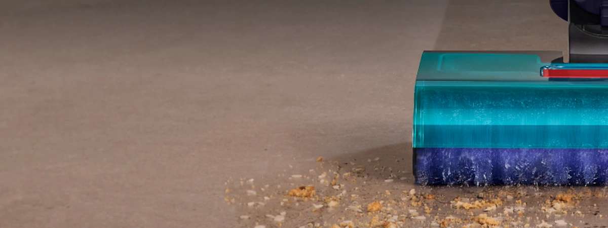 Крупний план лівої сторони щітки швабри під час роботи. Валик збирає бруд, крихти та змиває плями з підлоги.