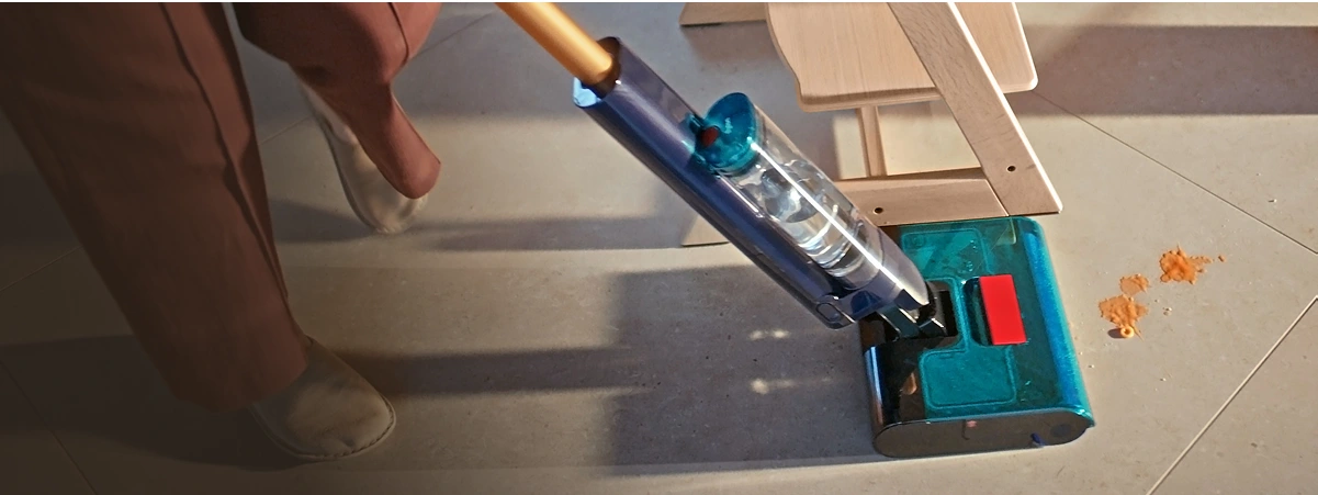 Вигляд швабри, яка маневрує поруч зі стільцем під час чищення брудної плитки на підлозі.