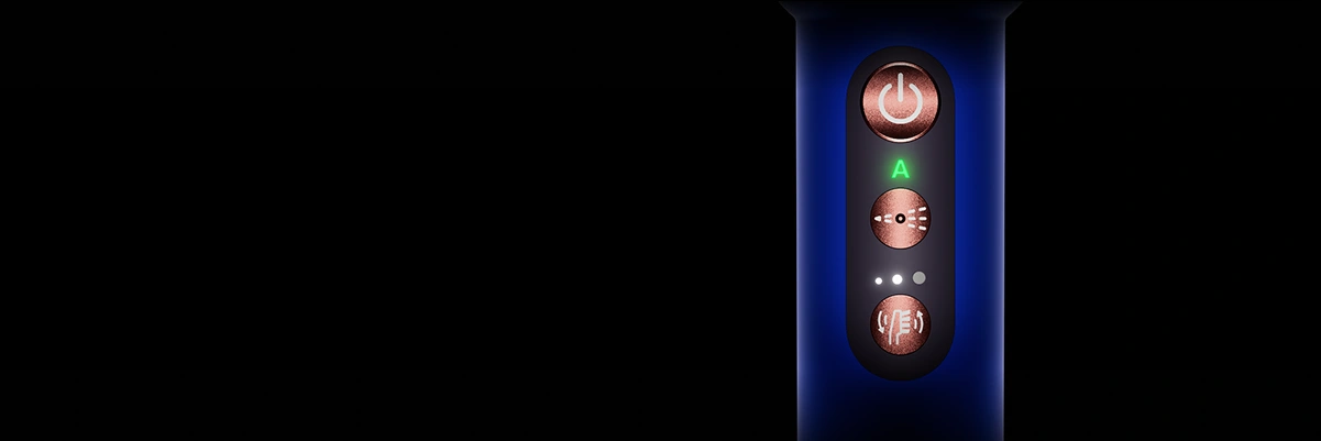 Крупний план синьої ручки зубної щітки Dyson та кнопок живлення, режиму чищення та інтенсивності чищення.