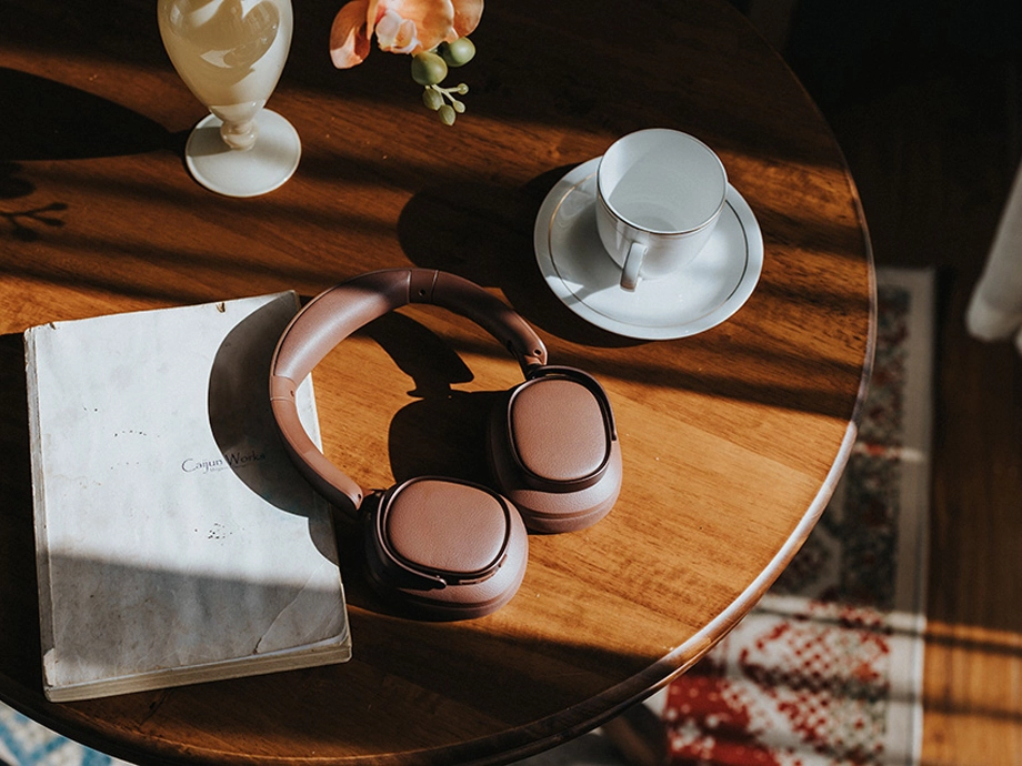 Рудоволоса дівчина в коричневих навушниках грає на укулеле