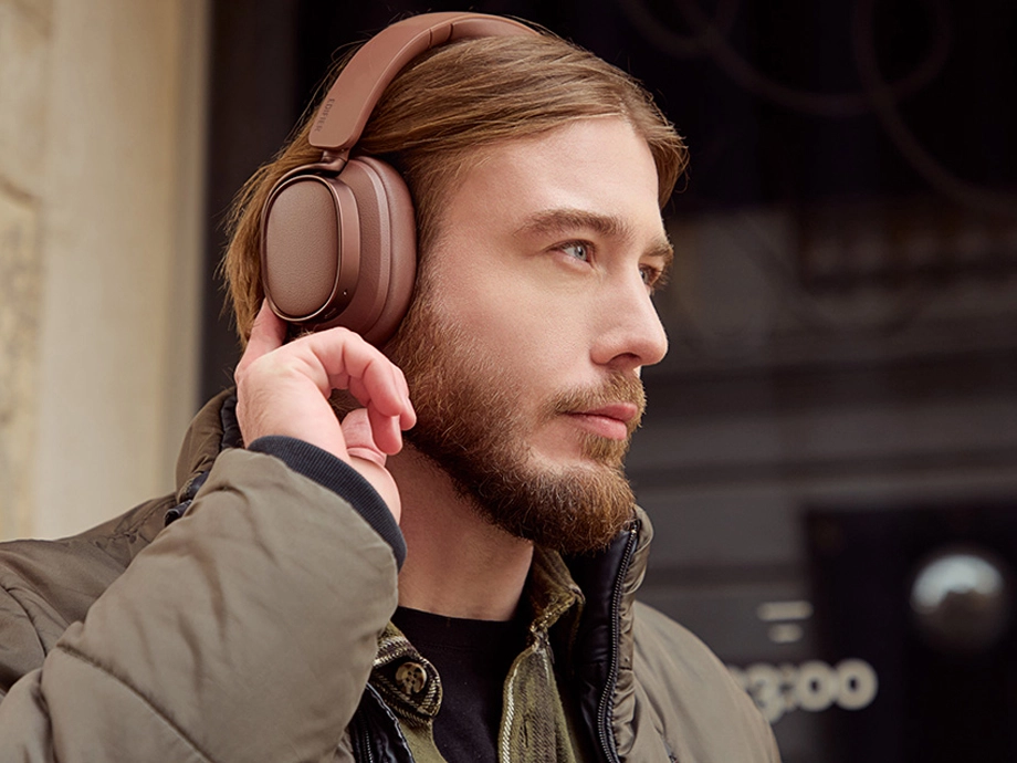 Бородатий чоловік у коричневих навушниках дивиться прямо перед собою