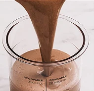 Густий шоколадний напій, налитий у прозору ємність.