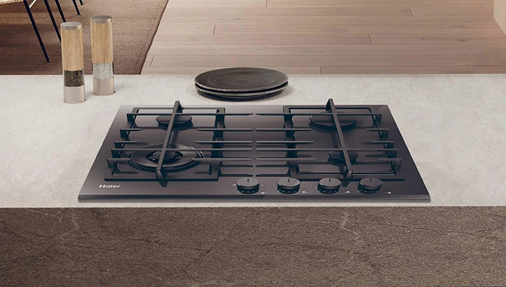 Чорна газова варильна поверхня з чотирма конфорками, розташована в сучасному кухонному інтер'єрі.