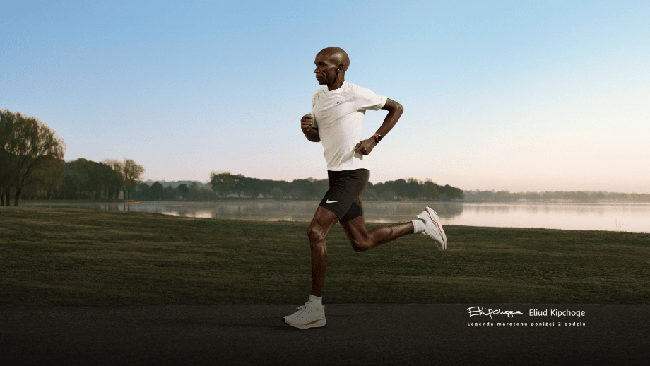 Легендарний марафонець Еліуд Кіпчоге біжить по траві на тлі озера, вдягнувши годинник HUAWEI Watch GT Runner 2.