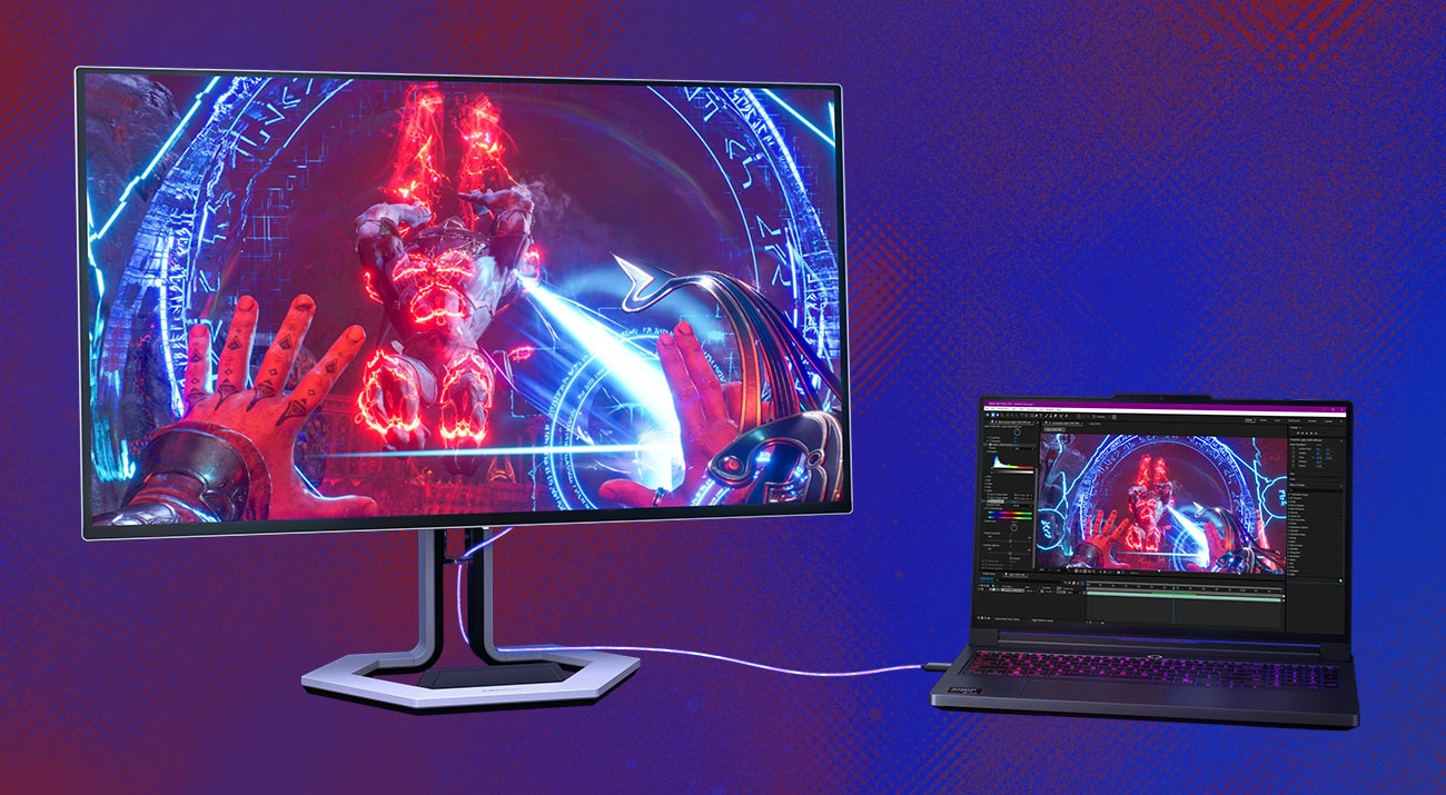 Монітор Lenovo Legion Pro 27Q-10, на екрані якого зображено сцену з комп'ютерної гри, та підключений поруч ноутбук