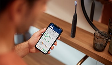 Чоловік тримає в руці смартфон, на екрані якого працює програма.