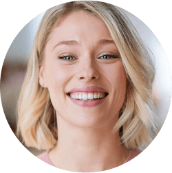 Жінка посміхається, показуючи зуби.