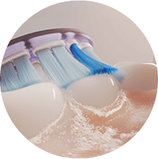 Крупний план зубної щітки, яка чистить зуби та утворює мікробульбашки.