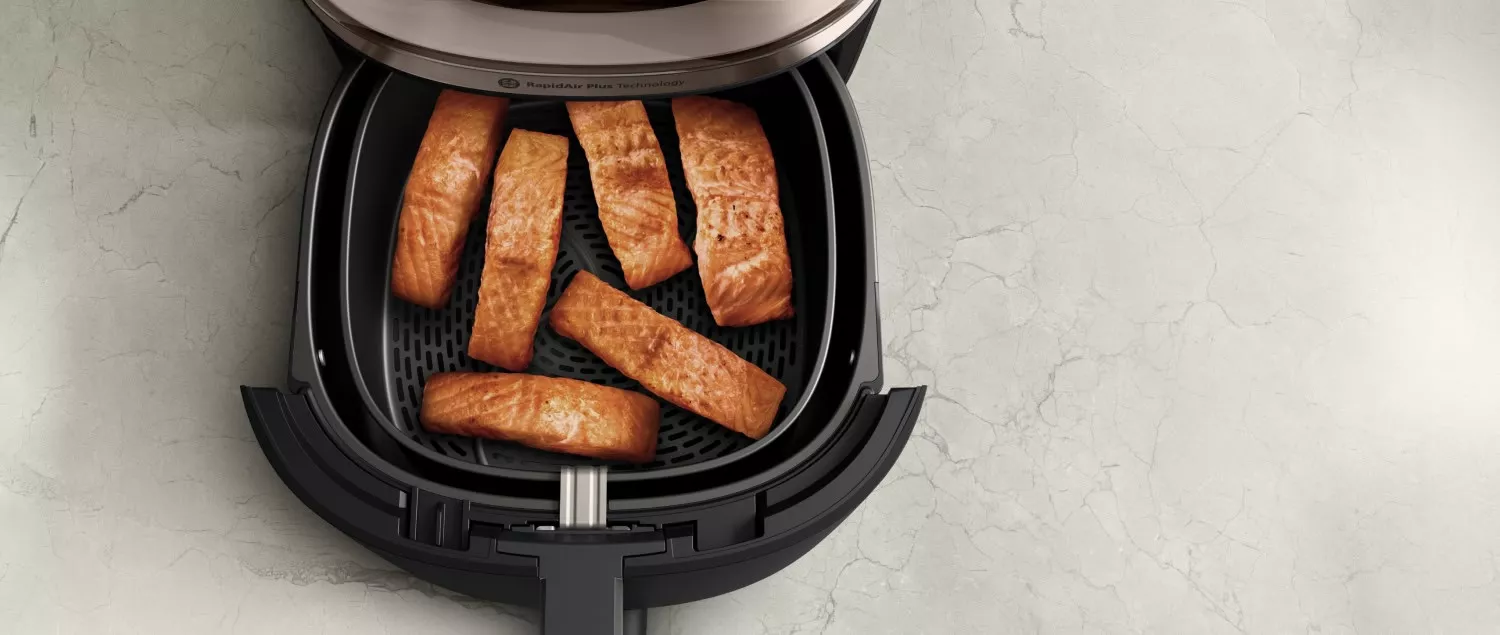 У кошику аерофритюрниці Philips NA547/07 знаходиться шість запечених філе лосося.