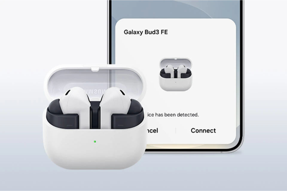 Galaxy Buds3 FE з відкритим зарядним футляром, розташовані перед Samsung Galaxy S25, демонструючи процес сполучення.