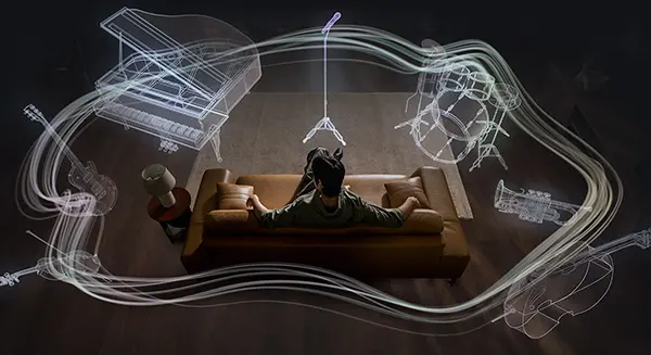 Чоловік на дивані, оточений контурами 360 аудіоінструментів: мікрофон, барабани, труба, віолончель, скрипка, гітара, фортепіано.