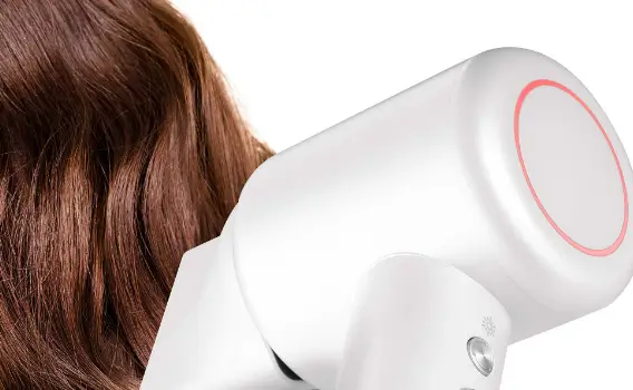 Крупний план фена Sencor, яким людина сушить волосся