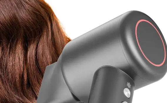 Жінка сушить волосся чорним феном Sencor.