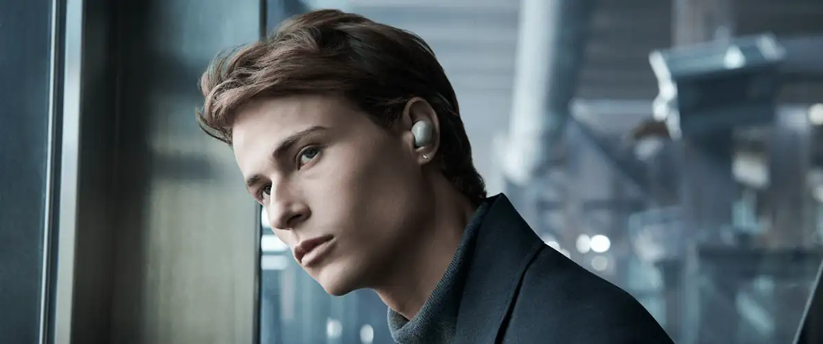 Чоловік у міському середовищі використовує навушники Sony WF-1000XM6