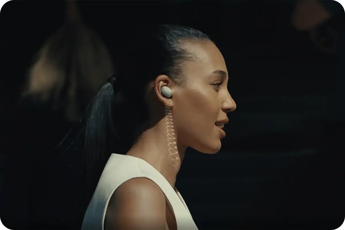 Жінка розмовляє через навушники Sony WF-1000XM6