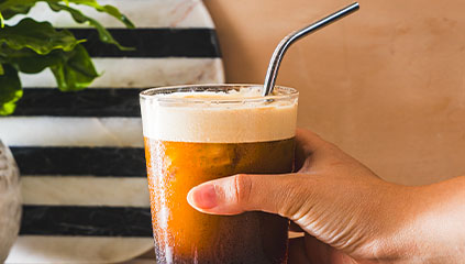 Крупний план кави, яку тримають у руці.