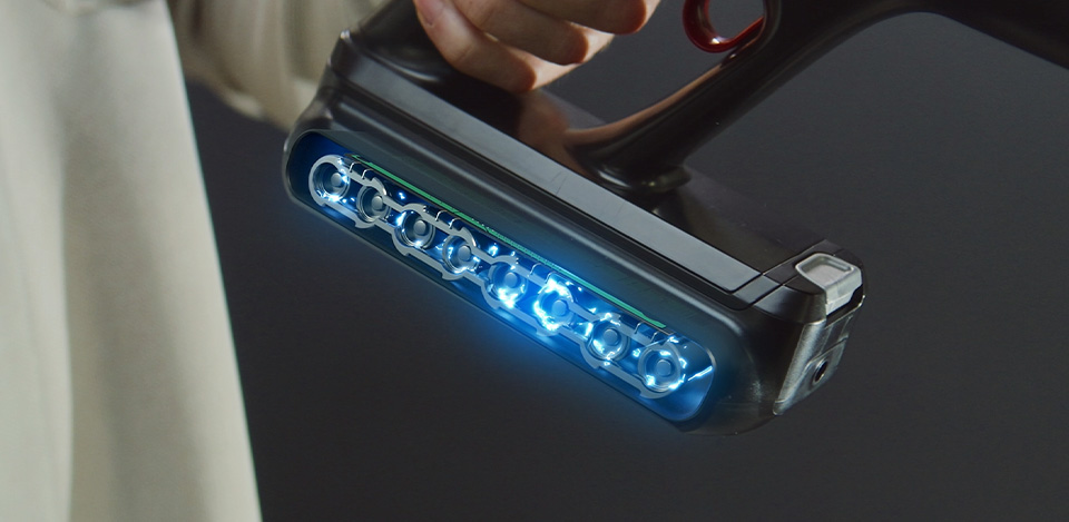 Розріз акумулятора пилососа Tefal X-Force Flex з синіми індикаторами. Пилосос у руці.