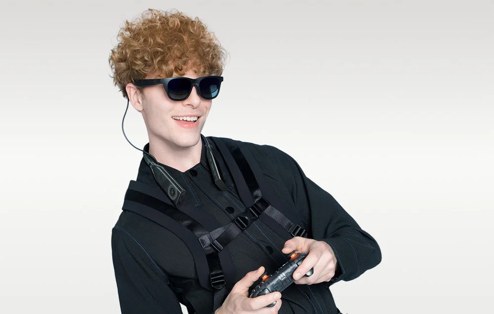 Усміхнений чоловік грає на консолі в окулярах XR (розширеної реальності)