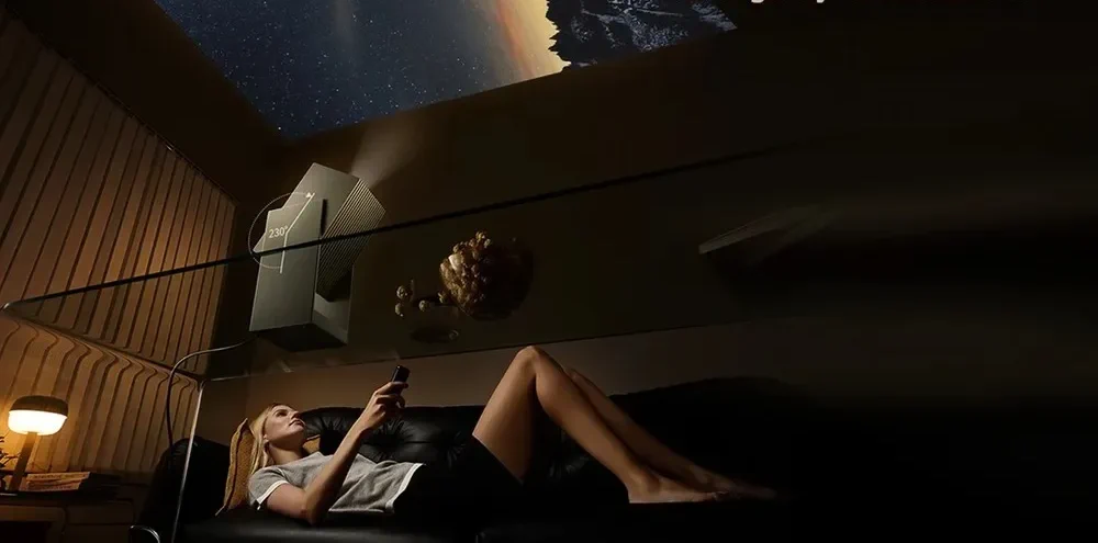 жінка відпочиває на дивані та дивиться зображення з проектора Wanbo Cube 2 Pro, що проектується на стелю