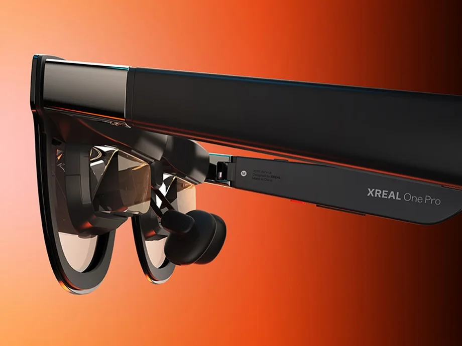 Окуляри XREAL One Pro, зображені збоку на помаранчевому фоні.