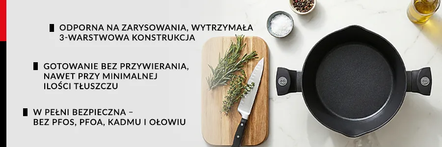 Garnek bez pokrywki stojący na blacie kuchennym, zdjęcie z góry po lewej stronie na desce do krojenia leży nóż oraz przekrojone zioła, na blacie leży również miseczka z pieprzem w ziarnach oraz z solą