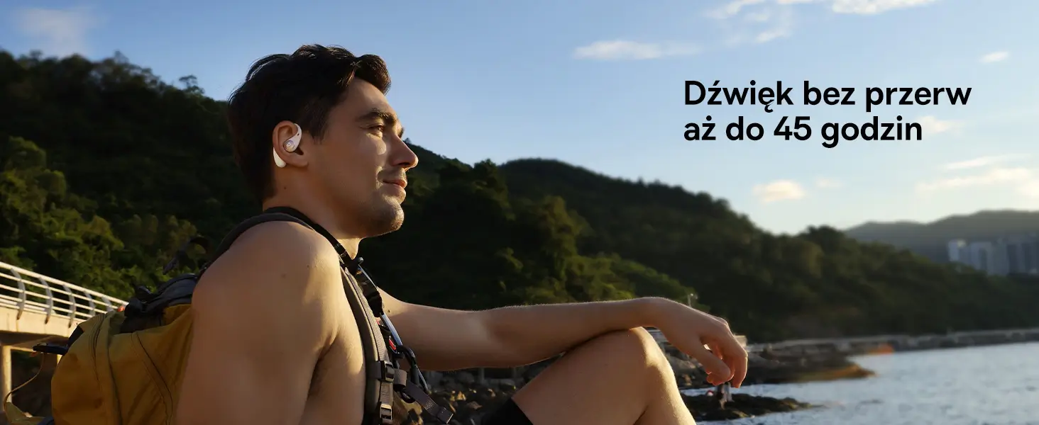 Mężczyzna w górzystym terenie w słuchawce dousznej Baseus Eli Sport 2 z baterią zapewniającą do 45 h pracy.