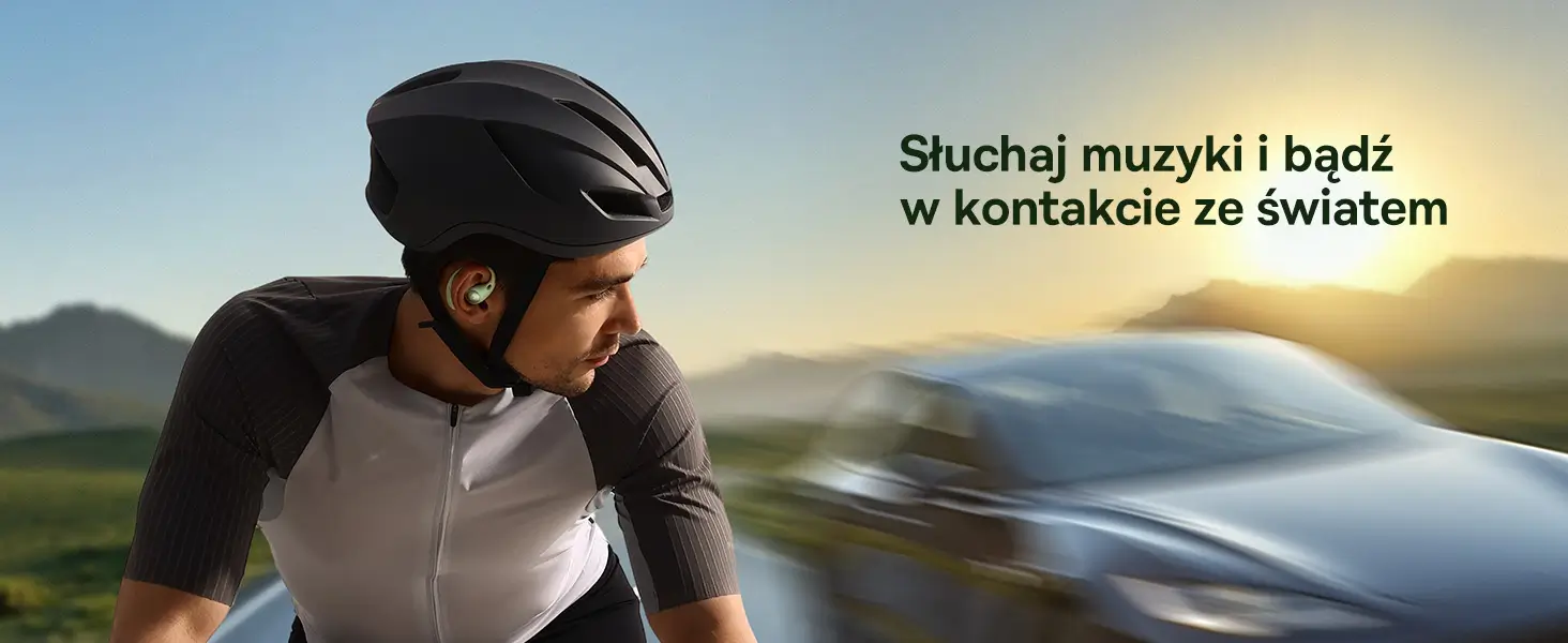 Rowerzysta w kasku jadący na szosie w zielonej słuchawce otwartej Baseus Eli Sport 2 słuchający muzyki.