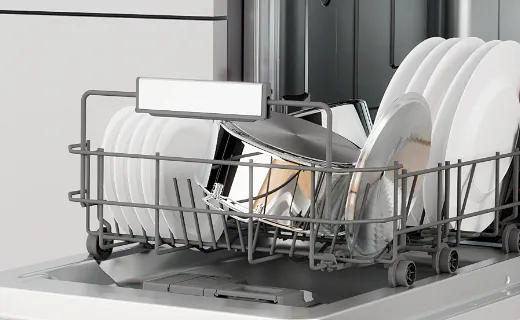 Відкрита вбудована посудомийна машина, наполовину заповнена посудом