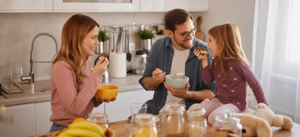 Жінка, чоловік і дівчина обідають на кухні;