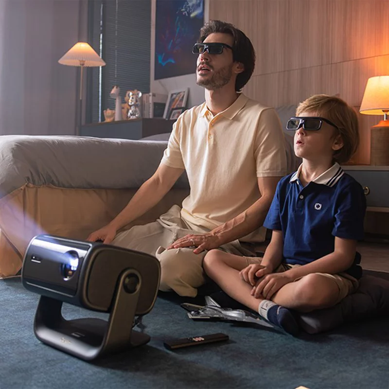 Батько і син у 3D-окулярах дивляться фільм на проекторі