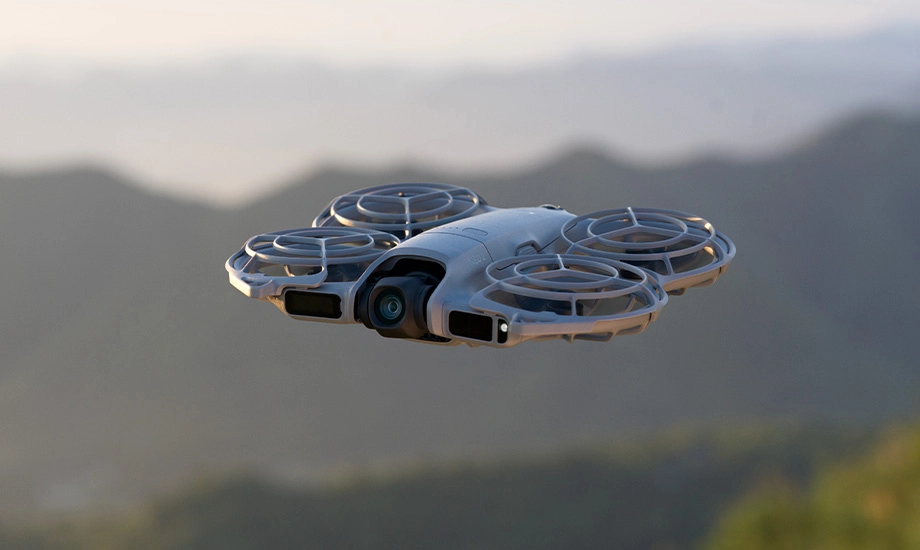 Дрон у польоті на тлі гірського пейзажу на заході сонця