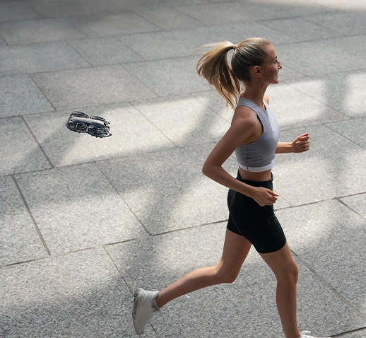 Жінка біжить, а поруч з нею летить дрон, слідуючи за нею.
