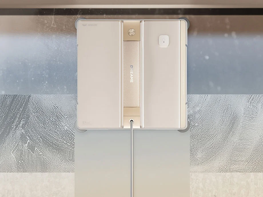 Пристрій для чищення працює на брудному вікні, з видимою смужкою вже очищеної поверхні.