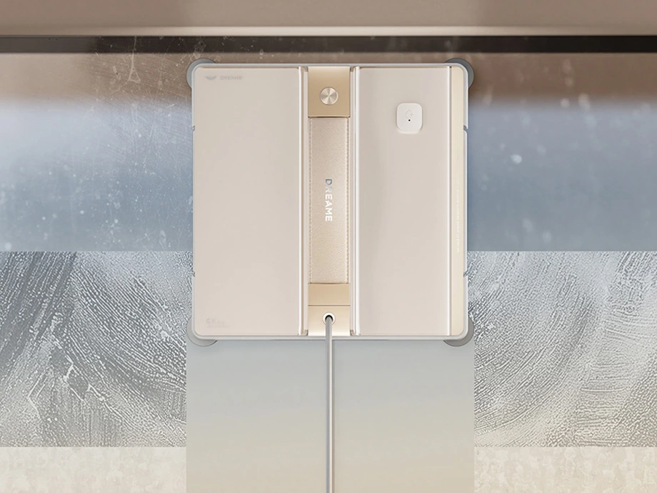 Крупний план робота-прибиральника, який працює над вікном, з видимими слідами очищення.