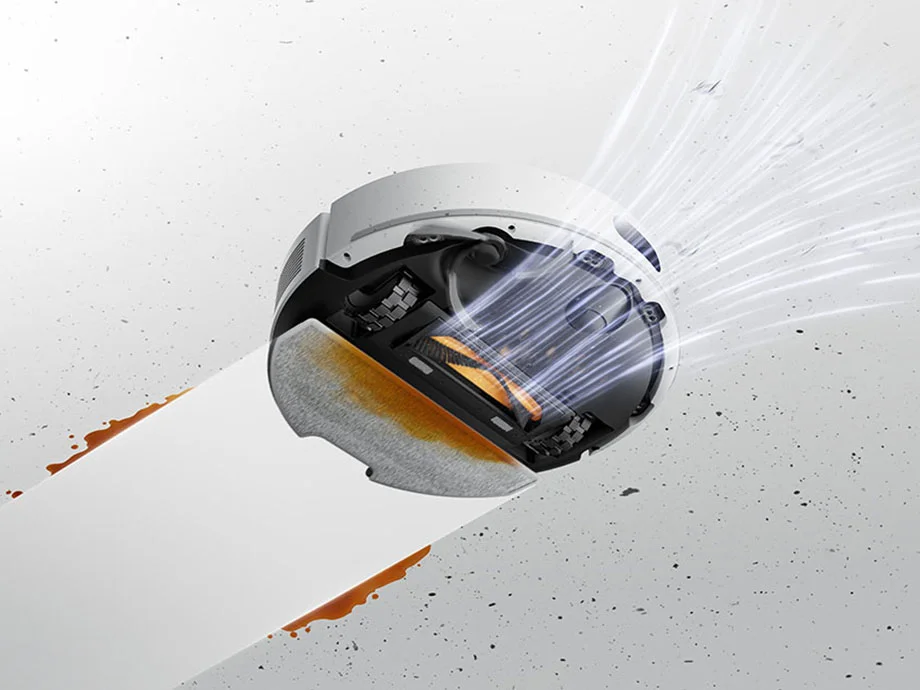 Нижня частина білого робота-прибиральника, який одночасно пилососить та миє поверхні.