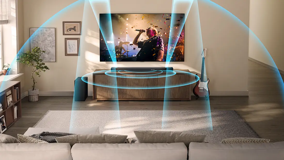 Саундбар AX3120Q, розміщений перед телевізором, випромінює блакитні звукові хвилі у вітальні.