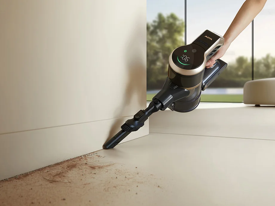 крупний план пилососа, який очищає край стіни від бруду